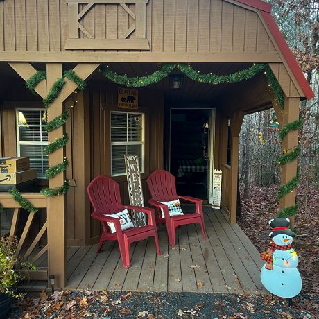 cabin porch with 2 chairs and decorated for Christmas and